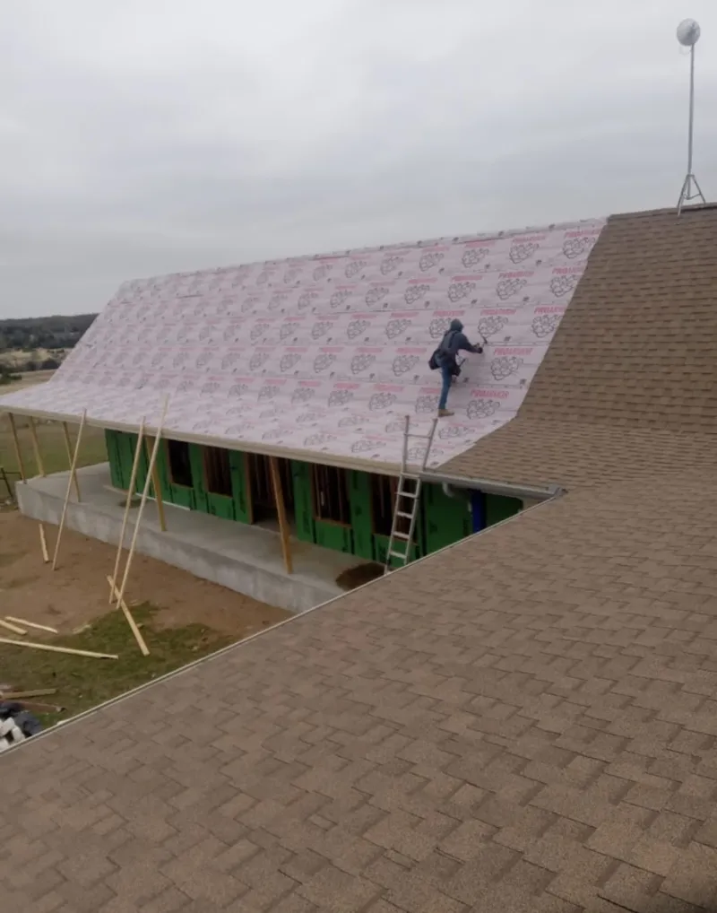 Worker preparing underlayment for a metal roof installation in Westchester